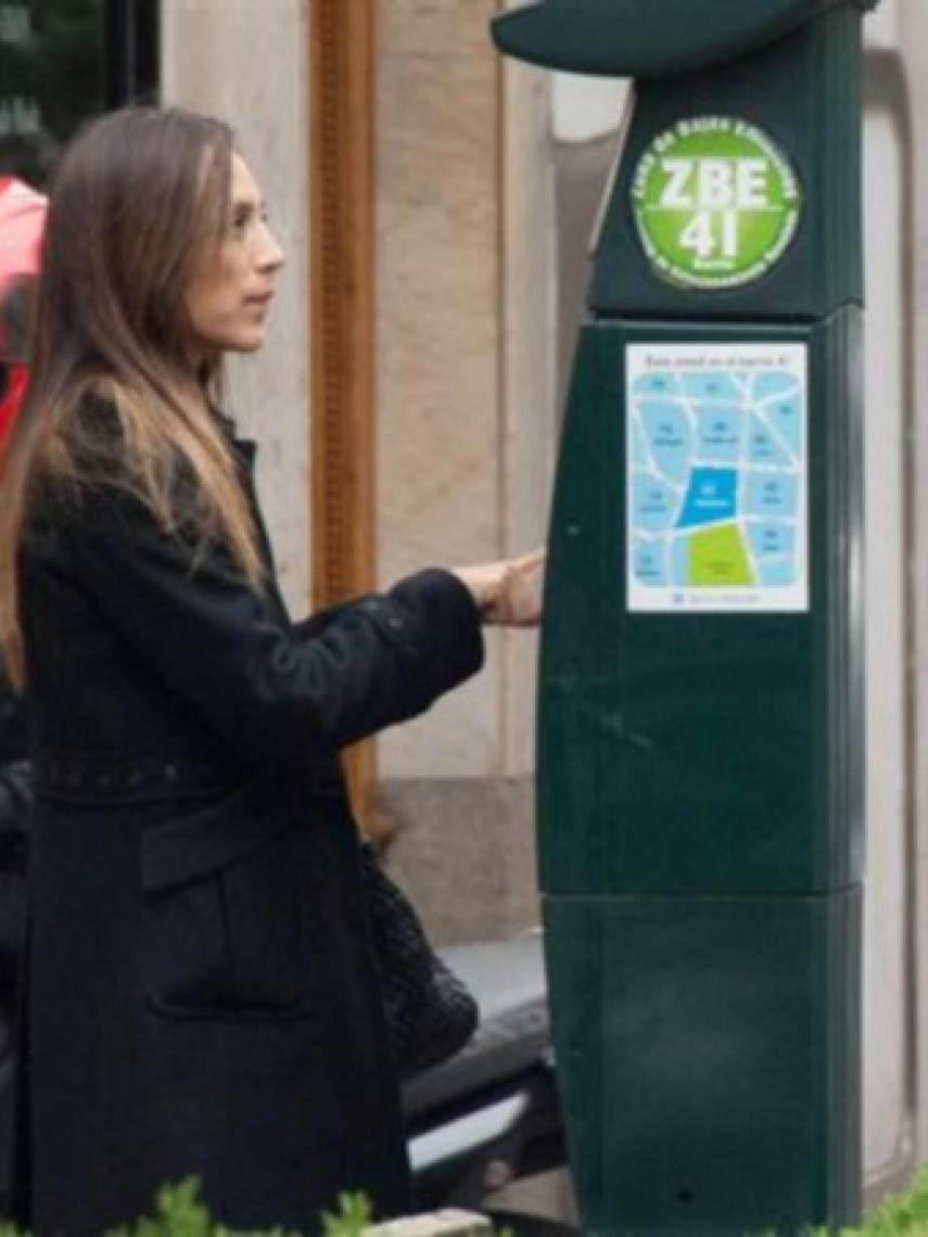 Tamara pagando la multa en el parquímetro.