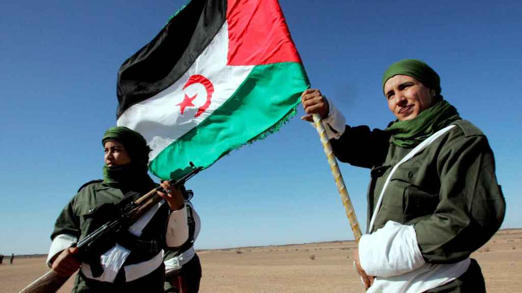 Una mujer soldado saharaui porta una bandera de la República Árabe Democrática del Sahara.