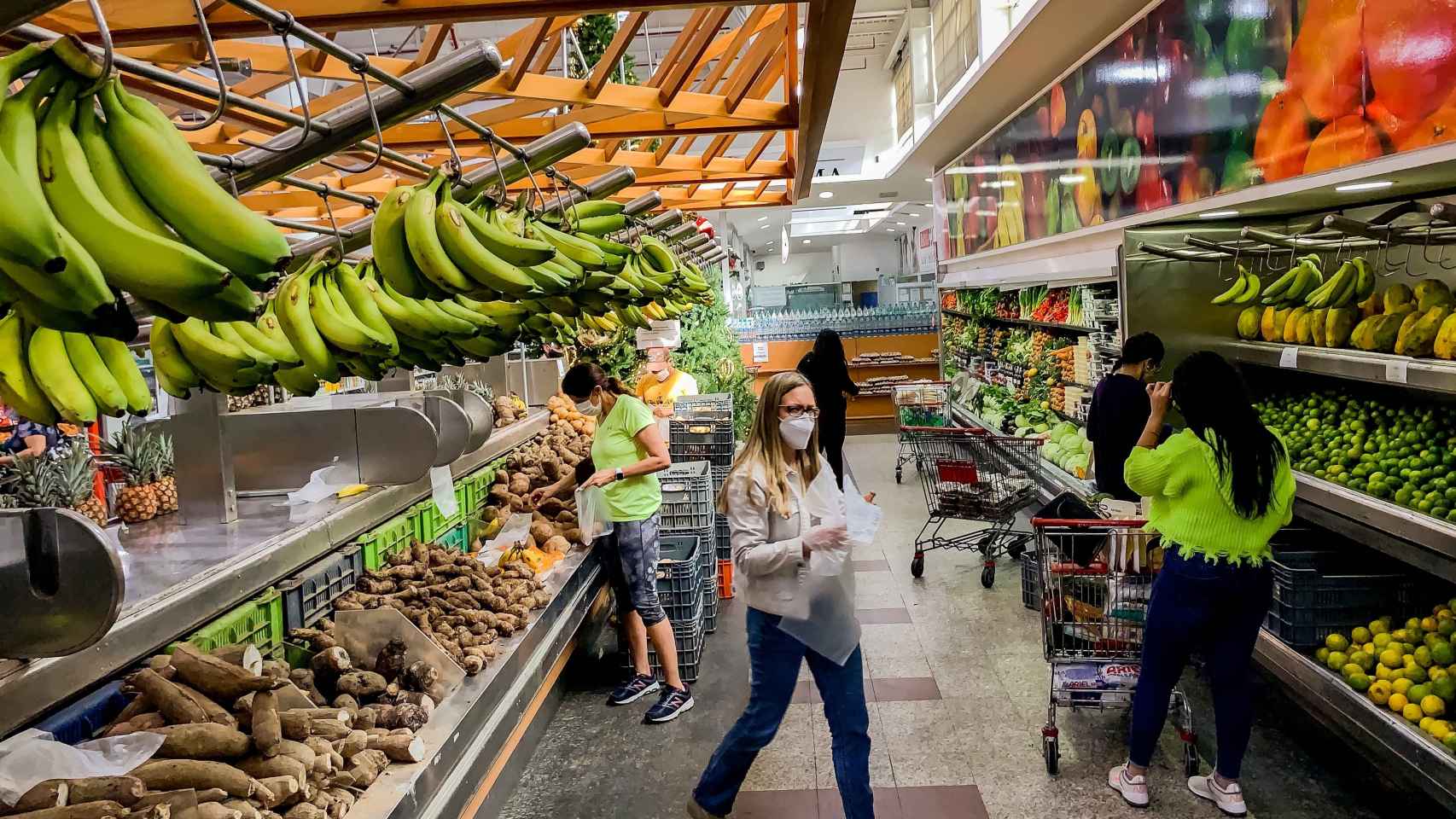 Clientes que recorren el pasillo de un supermercado, en Caracas.
