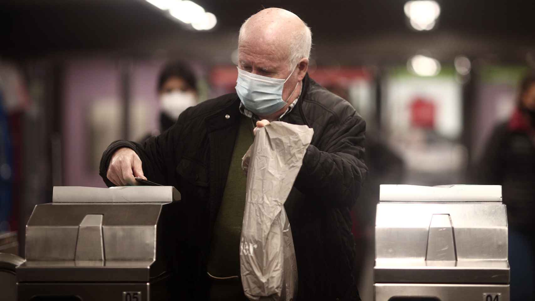 Un hombre, en el Metro de Madrid, usando una mascarilla quirúrgica.