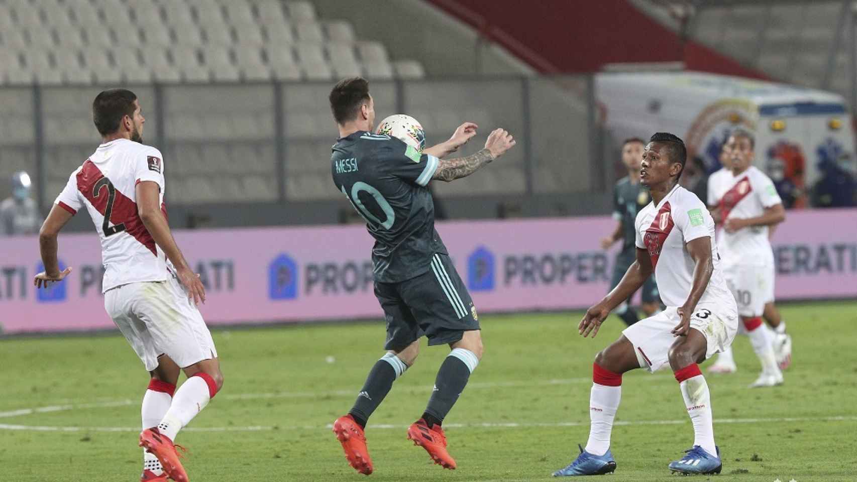 Messi controla un balón entre dos rivales de Perú