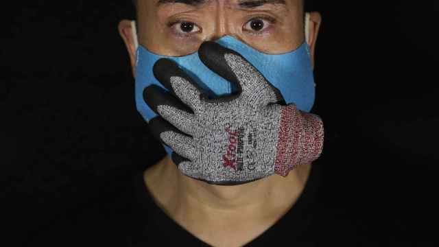 El artista Edmond Kok, de Hong Kong, con una mascarilla que representa la pérdida de voz/ Vincent Yu