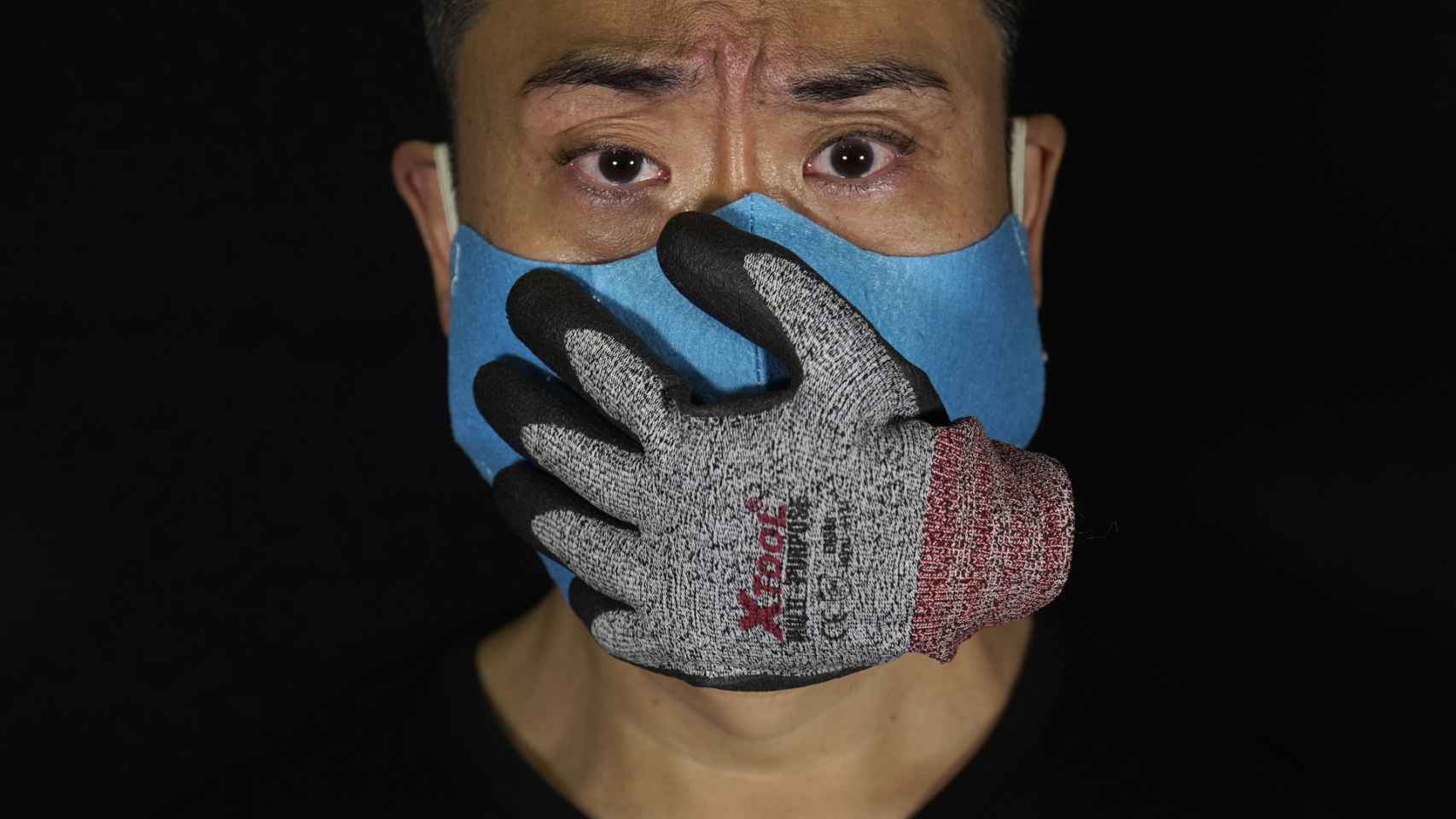 El artista Edmond Kok, de Hong Kong, con una mascarilla que representa la pérdida de voz/ Vincent Yu