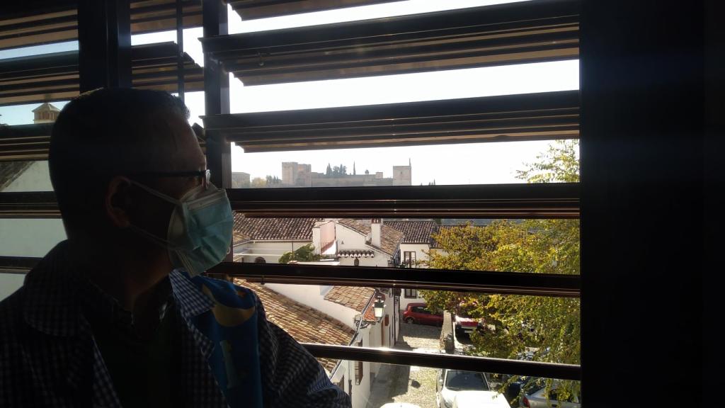 Un profesor del Colegio Gómez Moreno junto a una ventana de su clase que permite a los alumnos contemplar la Alhambra.