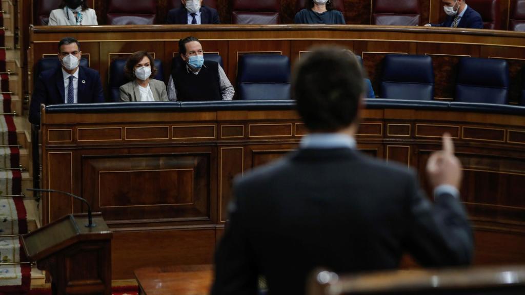 Casado, de espaldas, se dirige a Sánchez desde su escaño.