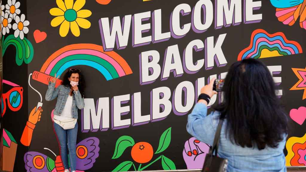 Una mujer toma una foto en el mural de  'Welcome Back', en Melbourne, Australia.