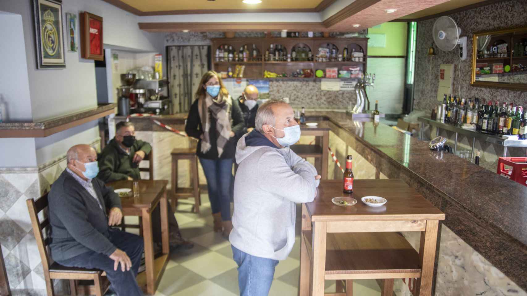 El bar del pueblo, con Tina, Paco, Teodoro y Juan José viendo las noticias.