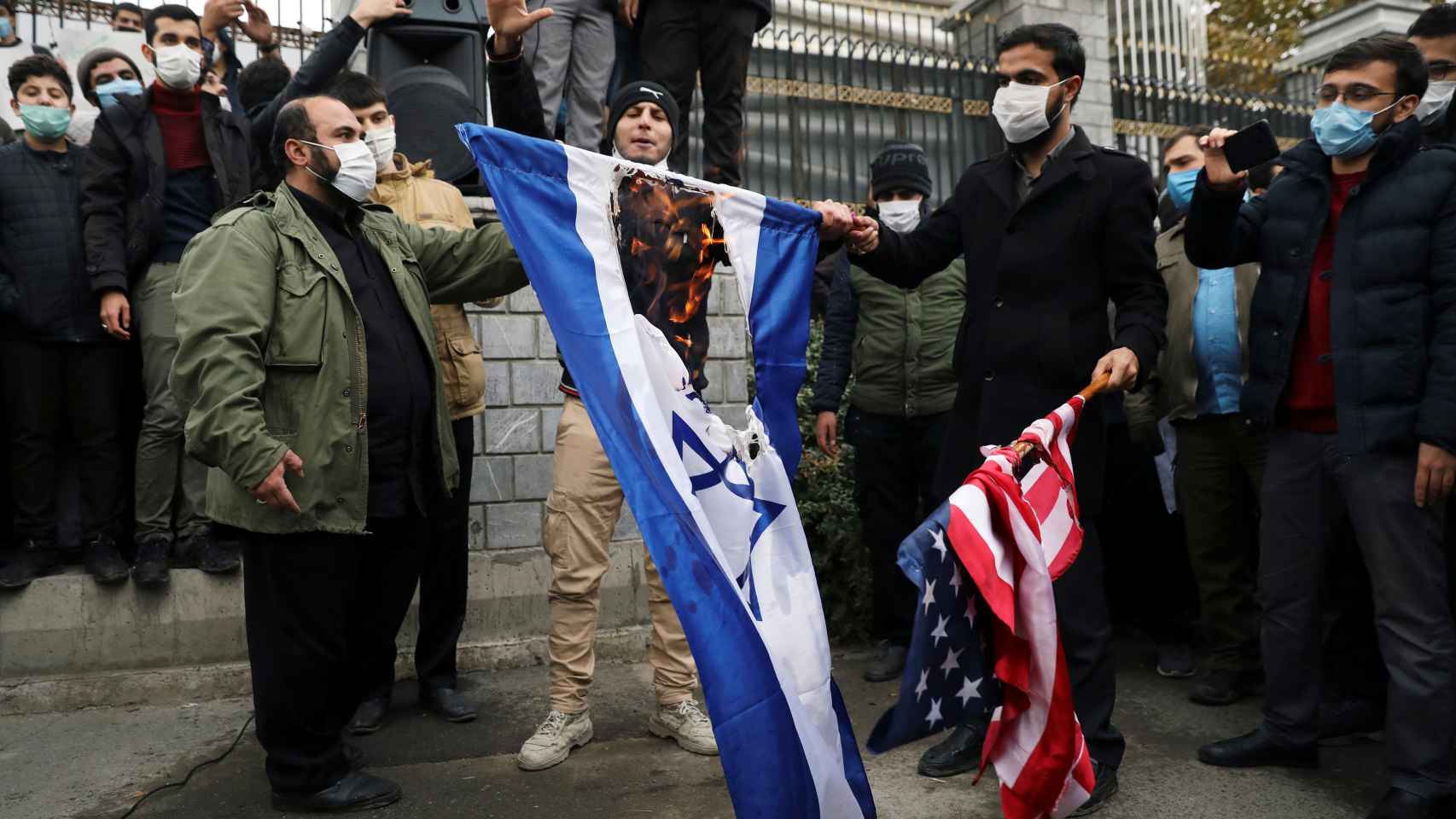 Manifestantes queman las banderas de Israel y EEUU en protesta por el asesinato de Mohsen Fajrizadeh.