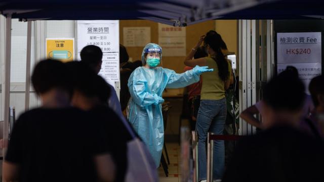 Una empleada sanitaria en un control de temperatura en Hong Kong.