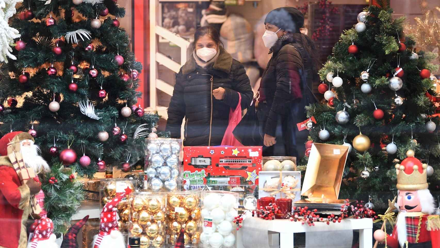 Dos mujeres con mascarilla frente a un escaparate navideño. EFE/EPA Daniel Dal Zennaro