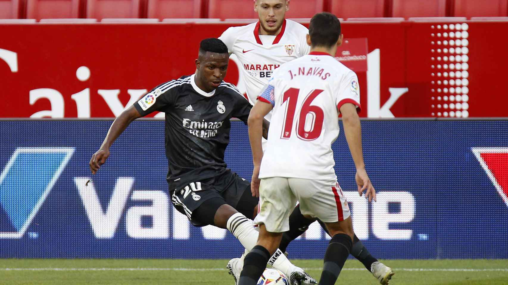 Vinicius evita la presión de dos jugadores del Sevilla