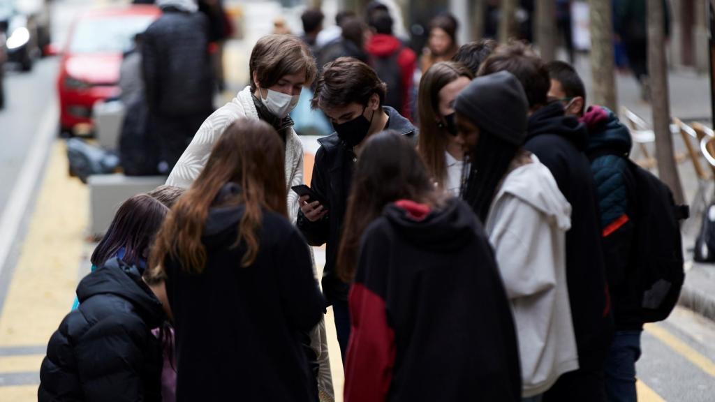 Varios jóvenes conversan en una calle de Barcelona este viernes.