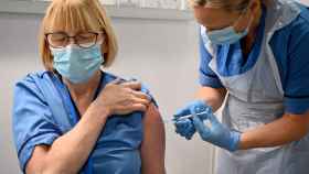 Una sanitaria vacuna a una compañera contra la Covid-19 en un hospital en Glasgow, Escocia.