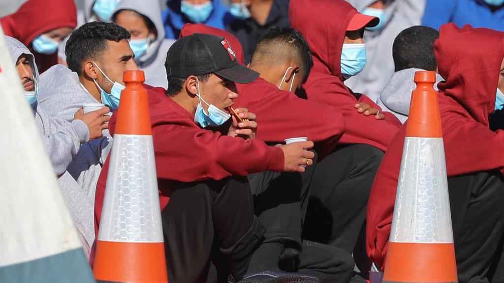 Varios inmigrantes rescatados al sur de Gran Canaria esperan a ser trasladados a Barranco Seco en el muelle de Arguineguín.