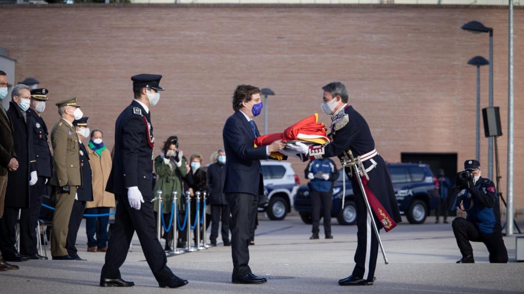 Almeida entrega la bandera nacional para su izado, en el cuartel de la Policía Municipal de Casa de Campo.