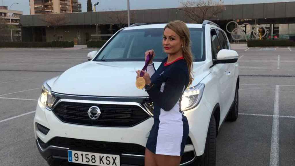Lydia Valentín, campeona olímpica y mundial, muestra su medalla junto al coche.