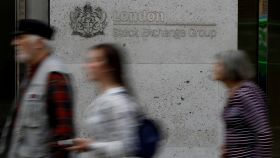 Varias personas caminan frente a la Bolsa de Londres.