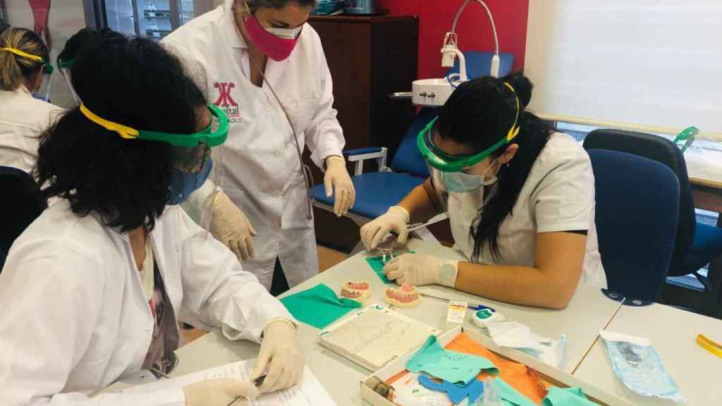 Dos alumnas diseñan impresiones para un aparato dental.