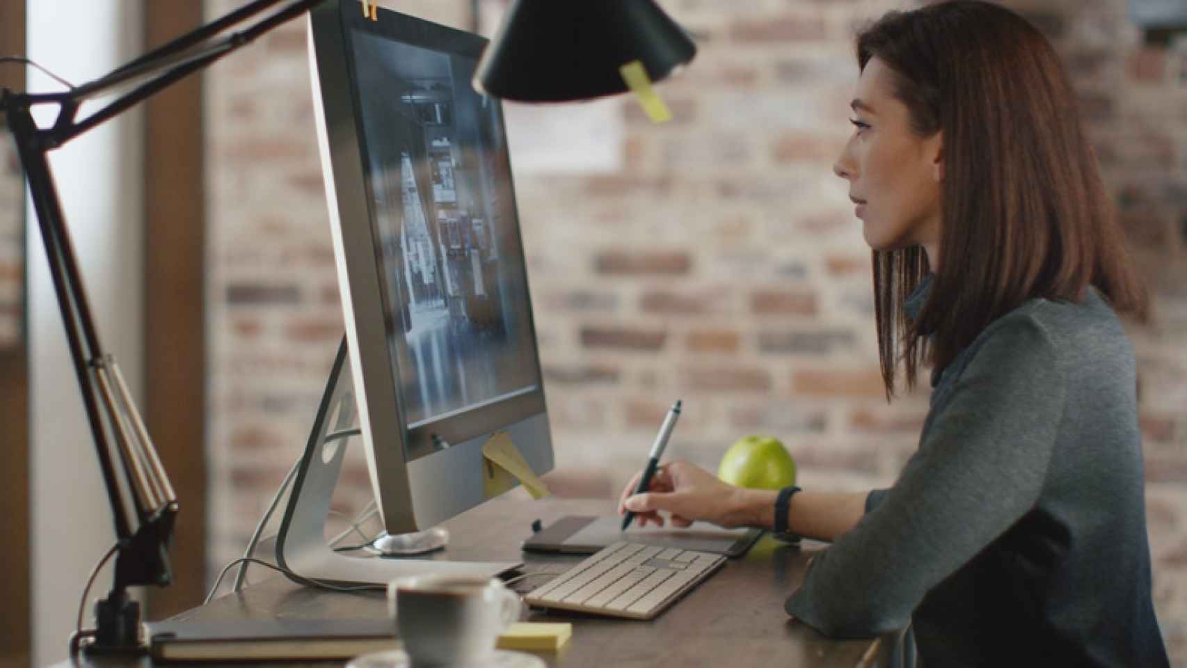 Una mujer trabajando frente a un ordenador.