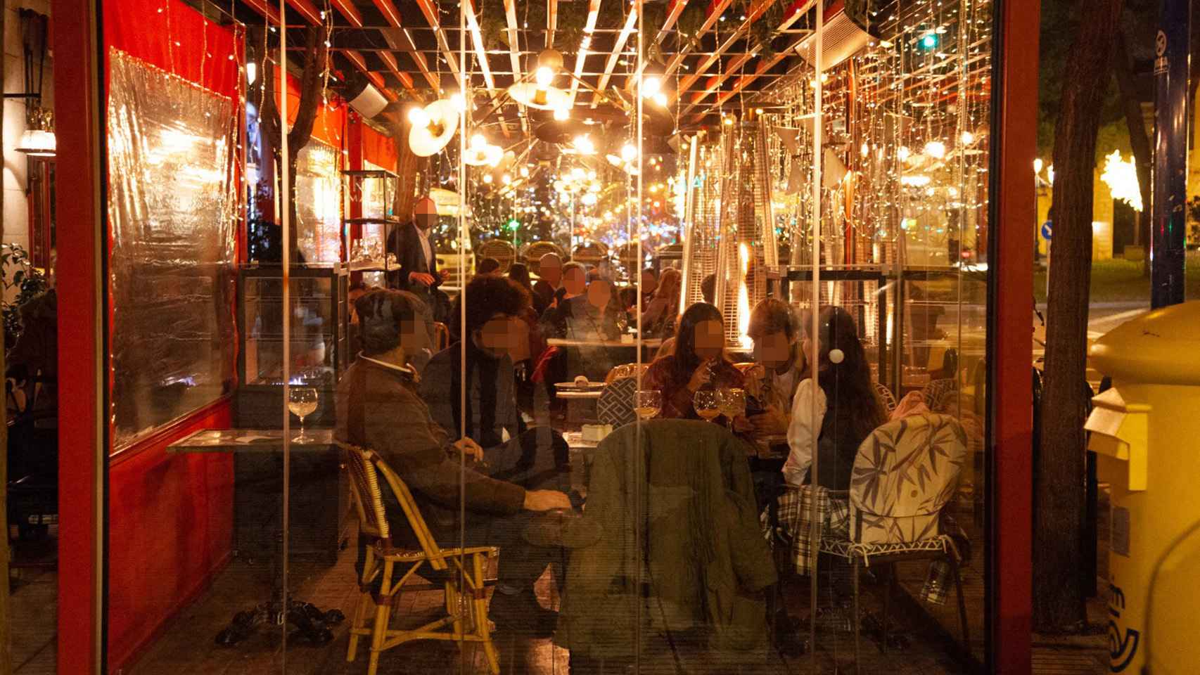 Clientes fumando en terrazas cerradas, en el restaurante El Martinete, la noche de este viernes.