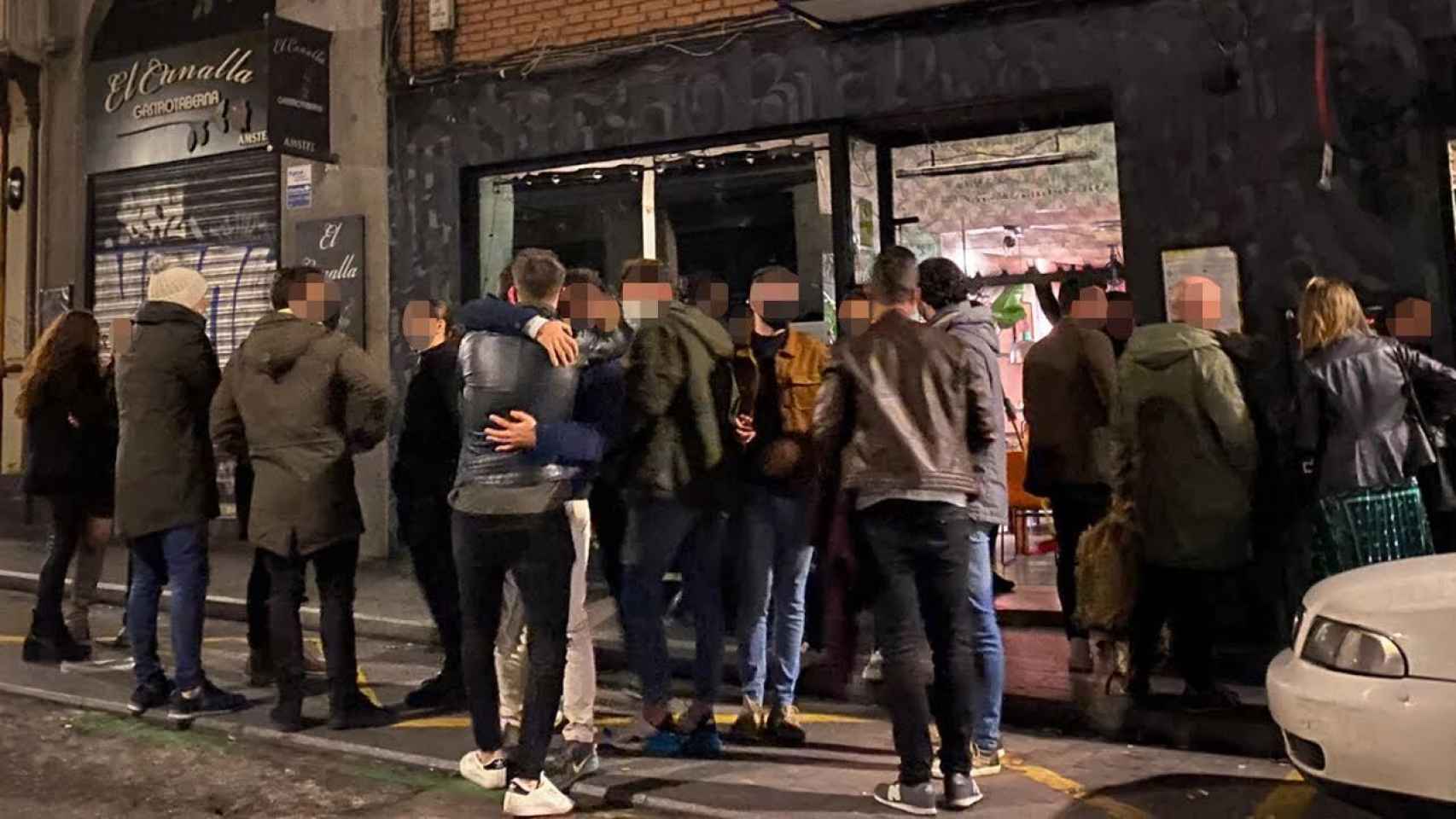 Un grupo de jóvenes se despiden ante el inminente cierre de un bar en el barrio de La Latina, en Madrid, la noche de este pasado viernes.