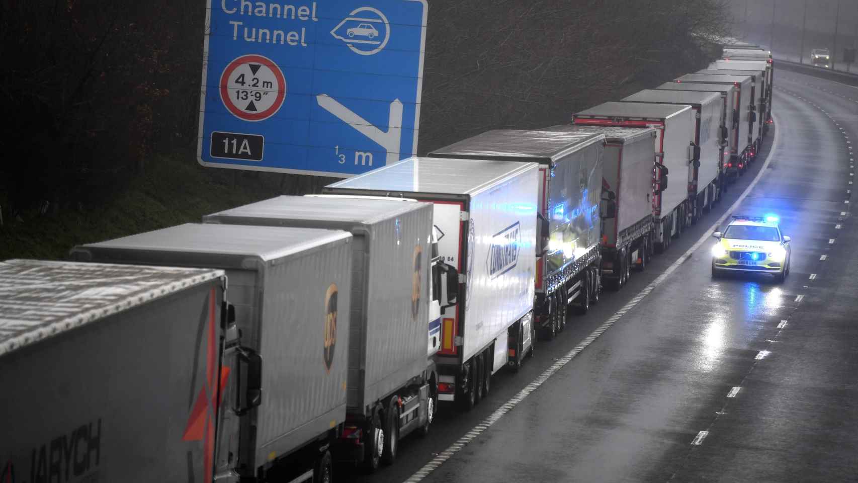 Un coche de policía pasa junto a una larga cola de camiones que permanecen atrapados a causa del cierre de la frontera con Reino Unido decretada por Francia.