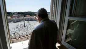 El papa Francisco se asoma al balcón que da a una Plaza de San Pedro vacía.