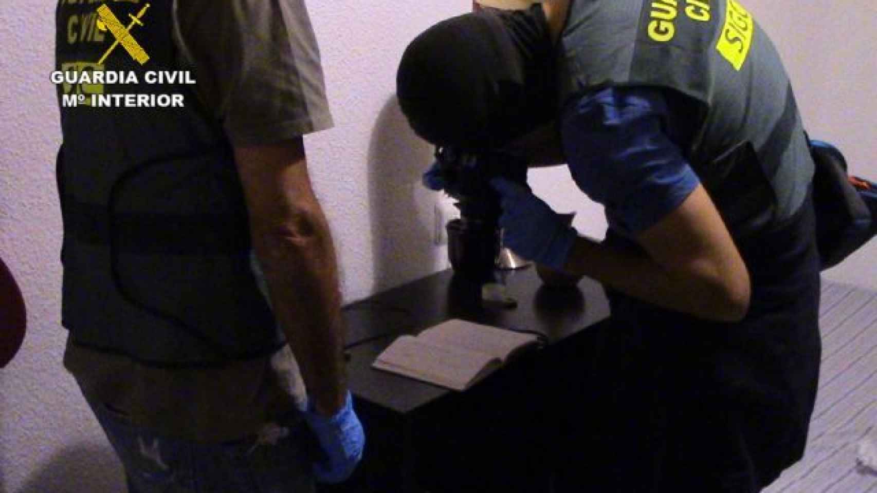 Dos guardias civiles durante el registro del domicilio del prófugo británico en su piso de Murcia.