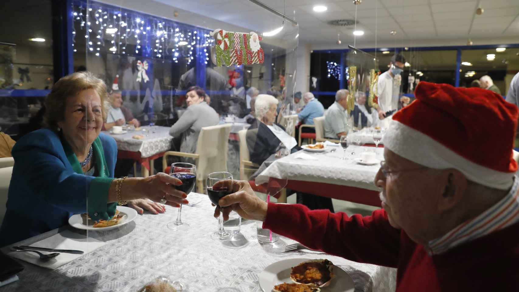 Adultos mayores residentes del centro Domus VI San Lázaro celebran durante la cena de Nochebuena.