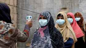Unas mujeres con mascarillas durante una campaña contra la polio en Karachi, Pakistán