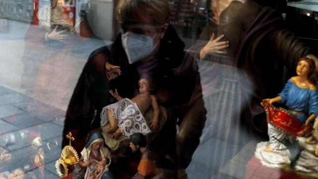 Una mujer con mascarilla frente a un escaparate de Madrid.