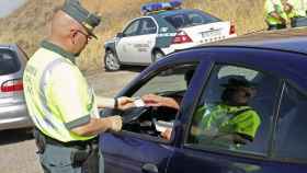 Un agente de la Guardia Civil solicitando a un conductor su documentación.