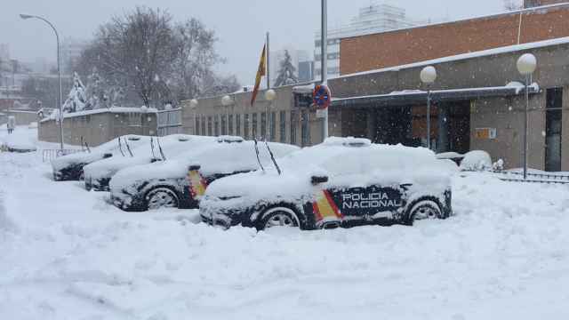 Los coches de la policía, completamente rodeados de nieve.