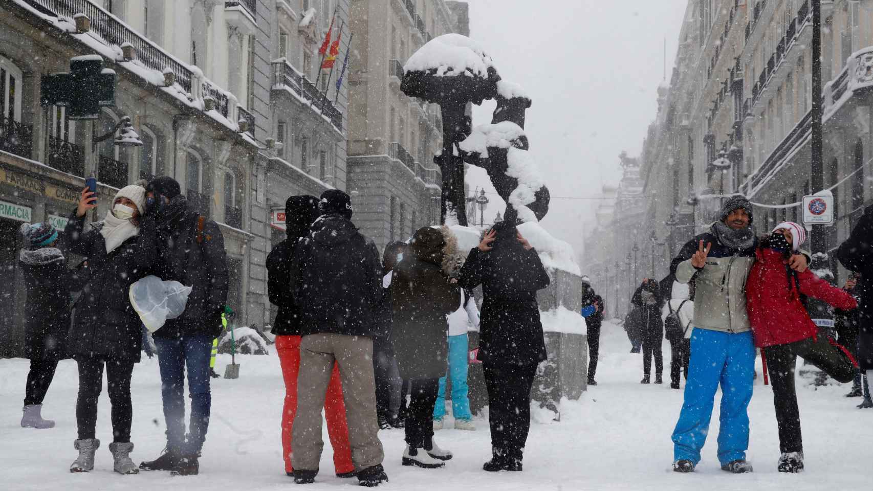 Viandantes disfrutan de la nieve en la Puerta del Sol en Madrid.