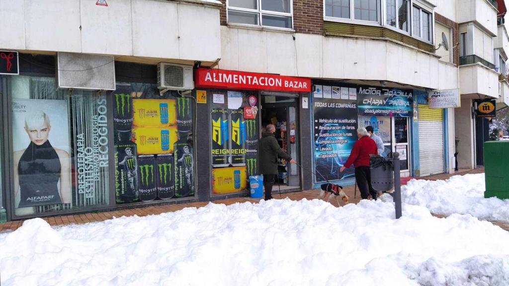 Varios clientes a las puertas de una tienda dirigida por un joven de origen chino.