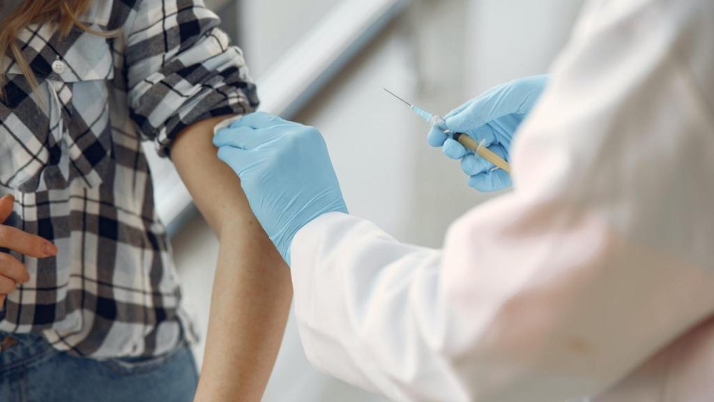 Un sanitario administrando una vacuna.
