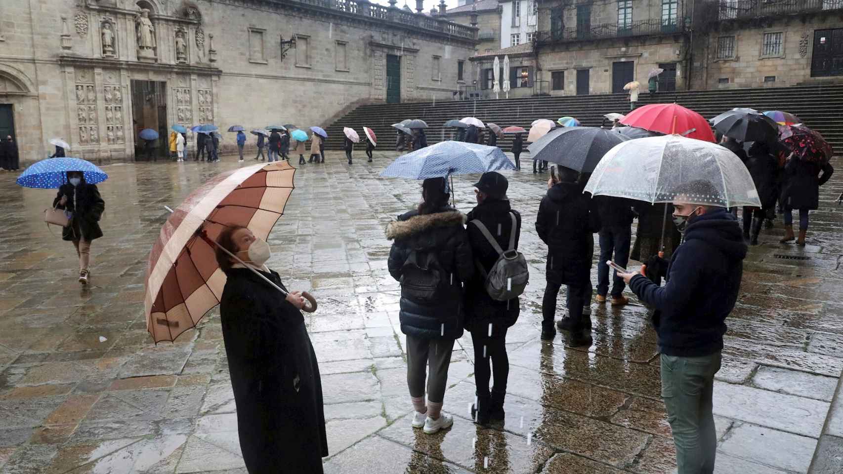 Personas hacen cola para acceder a la Catedral de Santiago por la Puerta Santa portando mascarillas y guardando la distancia de seguridad.