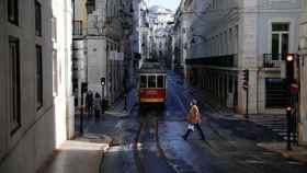 Una mujer cruzando la calle en Lisboa.