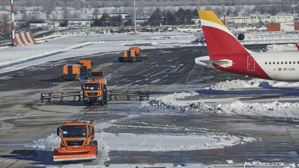 Varias excavadoras trabajan para retirar la nieve y el hielo de la pista de Barajas.