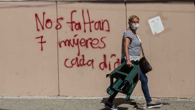 Una mujer camina frente a una pared con el mensaje: Nos faltan 7 mujeres cada día, en Ciudad de Guatemala.