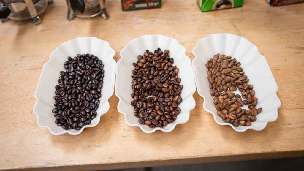A la izquierda, los granos de café tostado torrefacto y; a la derecha, dos naturales, más y menos tostados.