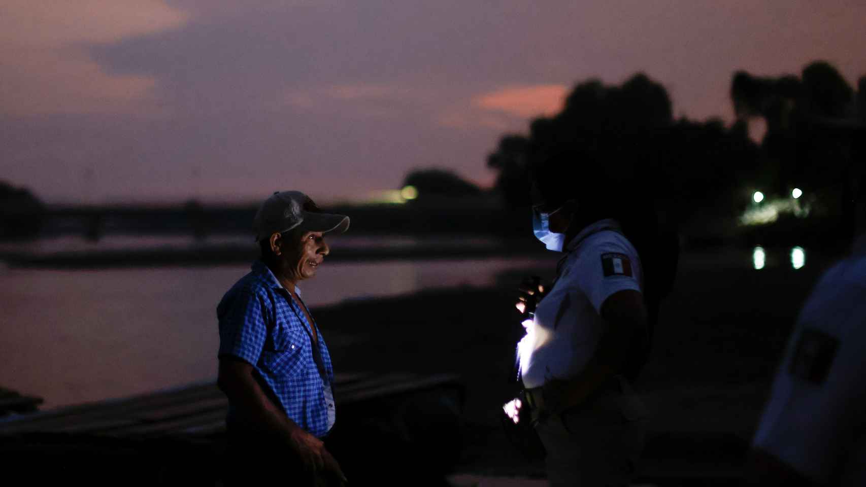Un policia pide la documentación e una hombre junto al río Suchiate.