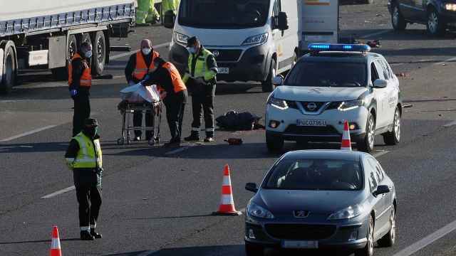 Agentes de la Guardia Civil junto al cuerpo sin vida de uno de los camioneros atropellados.