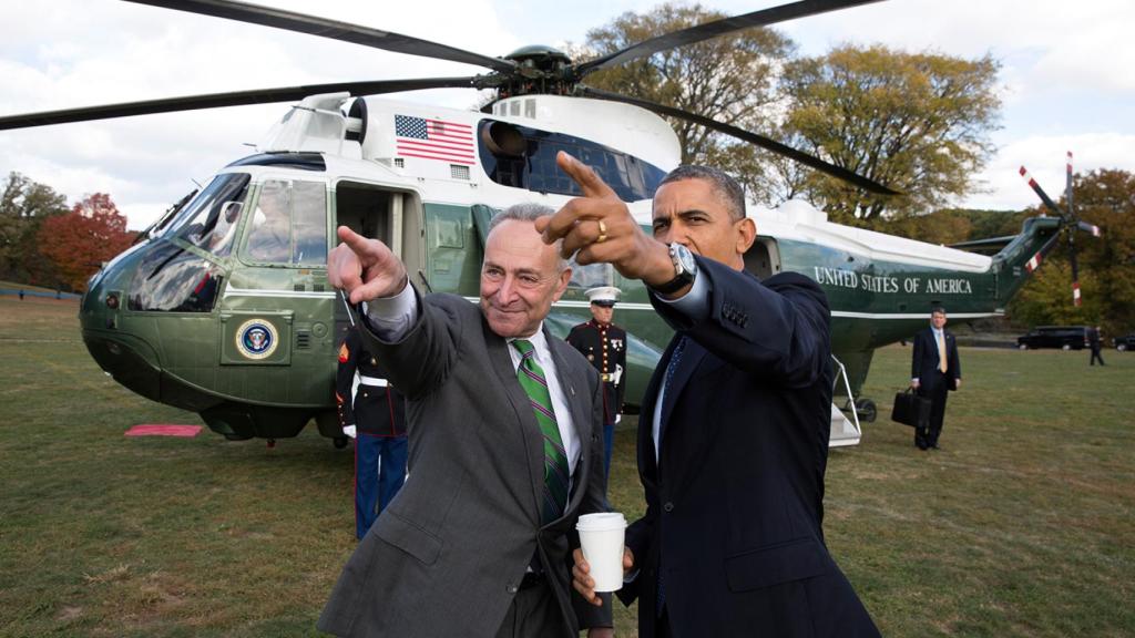 Presidente Barack Obama con un militar sujetando el maletín nuclear al fondo a la derecha.
