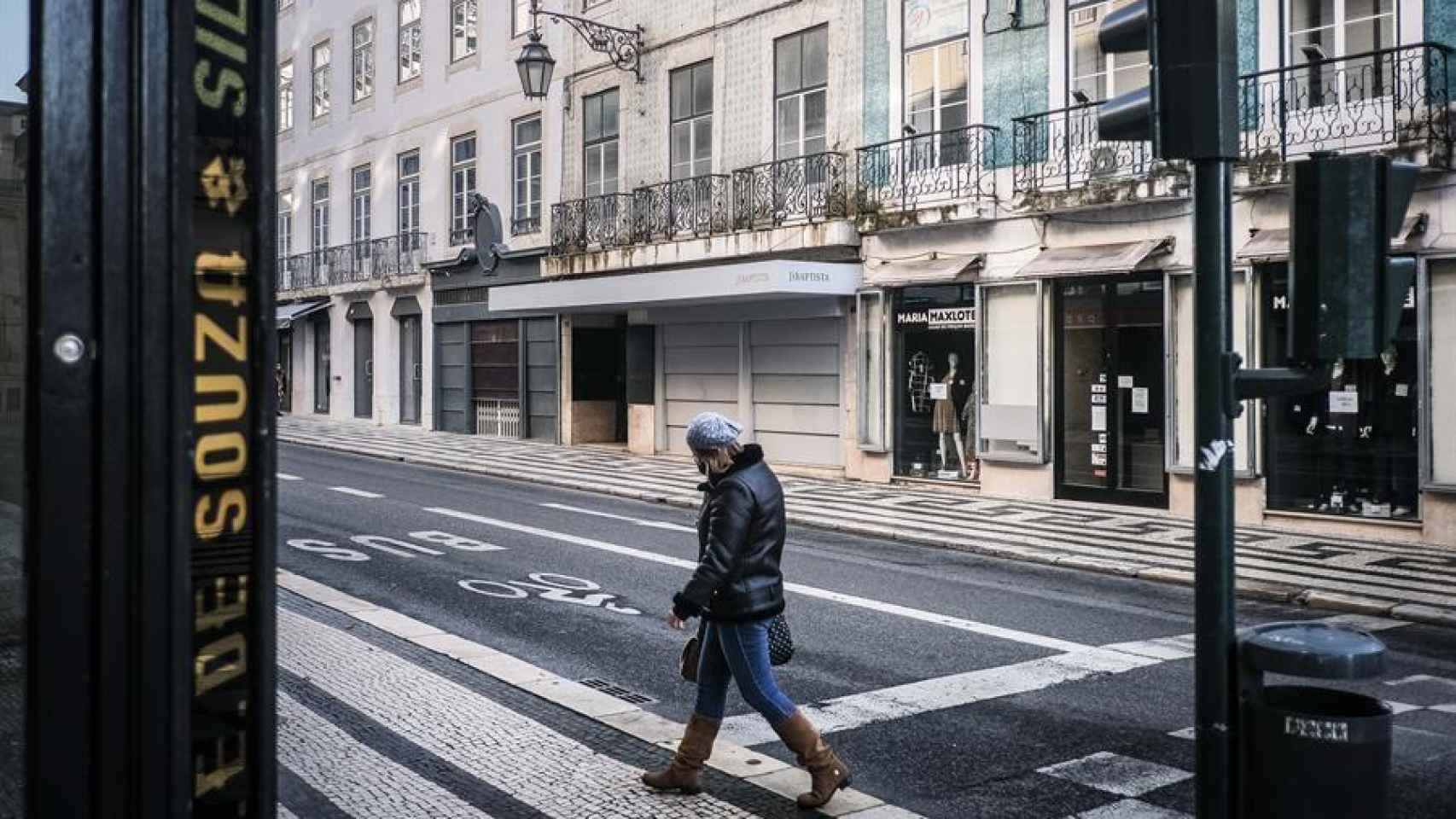 Una mujer pasea en una calle de Lisboa.