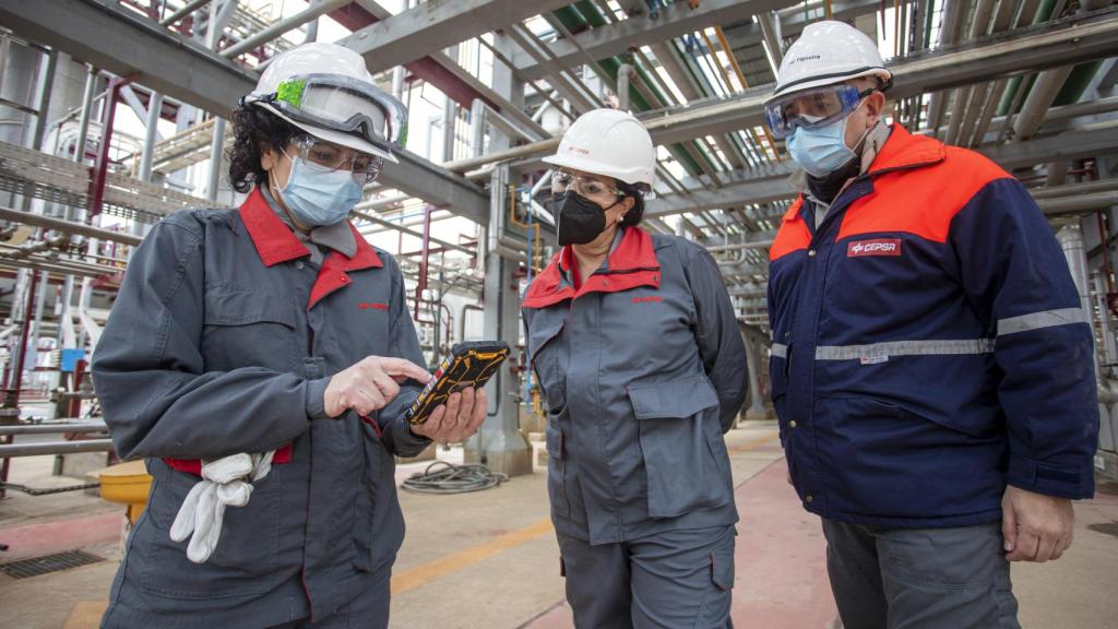 Esther González junto a dos trabajadores, dentro de una de las instalaciones de la planta.