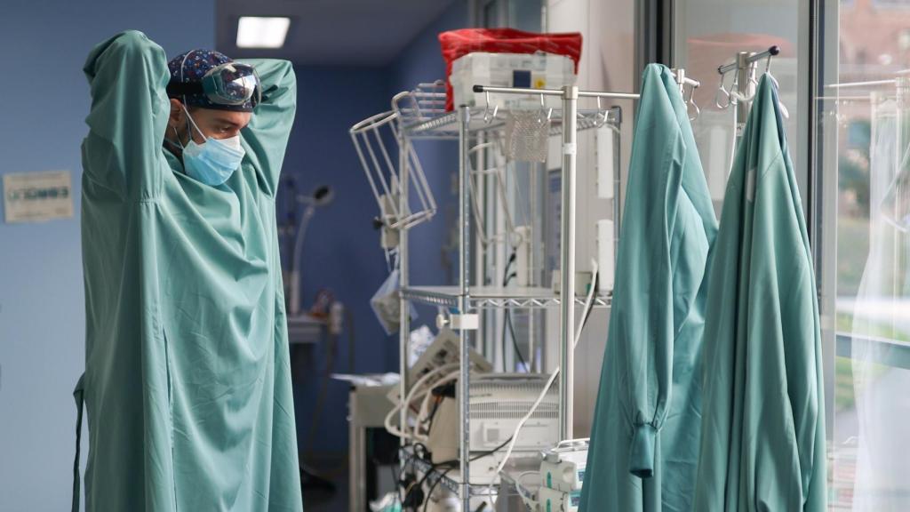 Un médico colocándose un EPI.