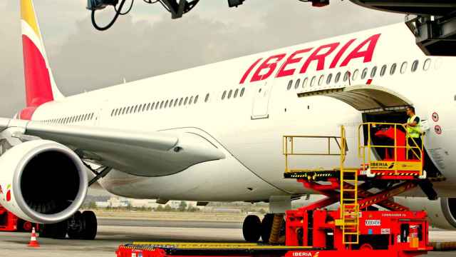 Un avión de Iberia (IAG) carga en un aeropuerto antes de iniciar su vuelo.
