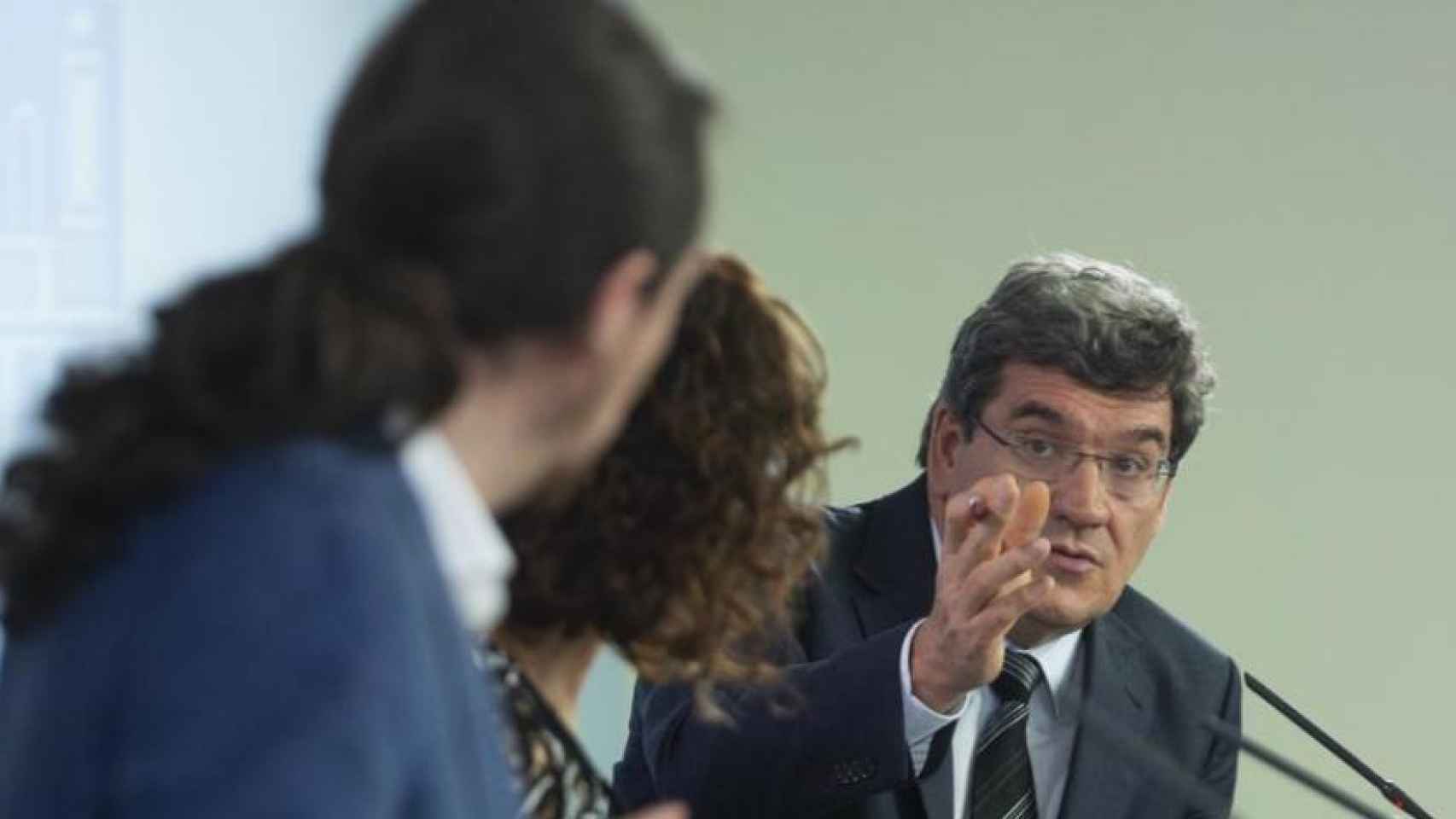 El ministro José Luis Escrivá apostilla al vicepresidente Pablo Iglesias, en presencia de la ministra María Jesús Montero.