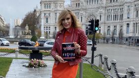 María Eizaguirre posa junto a su nuevo libro frente a la llama por las víctimas de la Covid en Madrid.